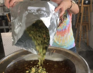 Barley and hops being added to a craft beer at Brewery 99.